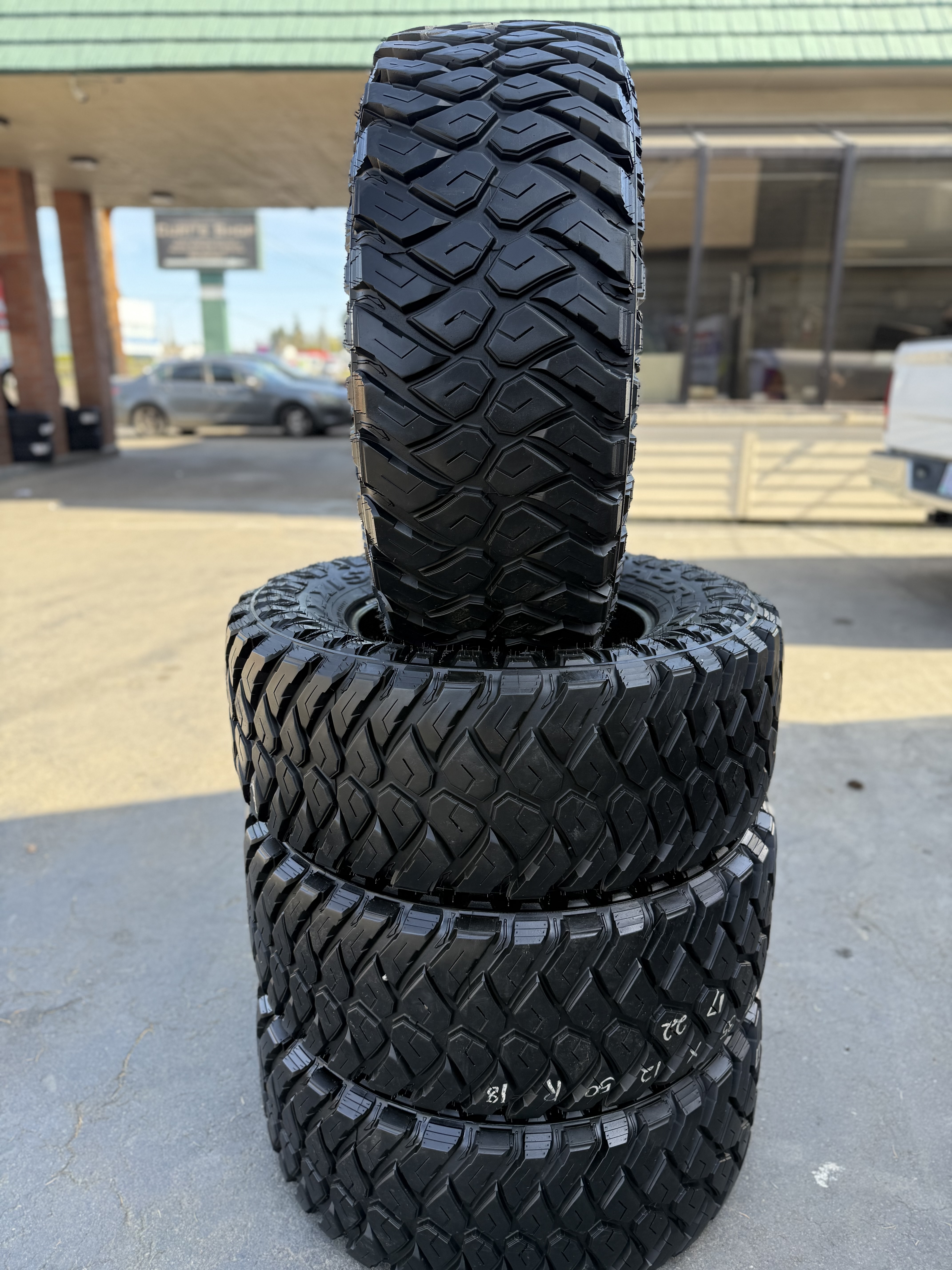 stacked off-road tires displayed outside MC Wheels and Tires